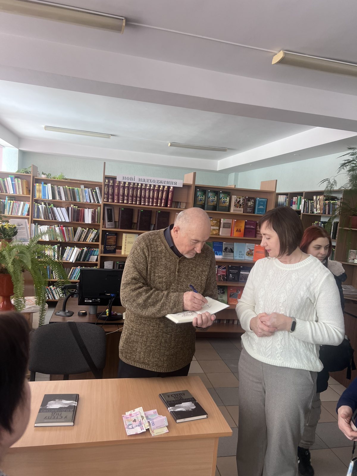 Oleksandr Vilchynskyi pidpysuie prydbanu knyhu "U stepu pid Avdiivkoiu"